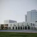 Modern Multi Story Office Building With Large Windows Surrounded By Trees Greenery And Lawns