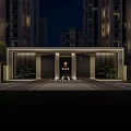 Illuminated Residential Entrance With High Rise Buildings And Landscaped Greenery At Night