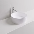 Modern Round White Washbasin on White Countertop with Silver Faucet Against Light Gray Wall