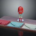 Red Top And Blue Bottom Mannequin With Three Fabric Stacks On Wooden Display Table