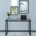 Modern Glass Top Desk With Green Plant Vase Laptop Books and Framed Botanical Prints