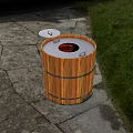 Outdoor Wooden Barrel Grill With Open Lid On Stone Pavement And Grass Area
