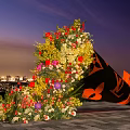 Colorful Flower Display With Black Cone Decoration Against City Night Sky Background