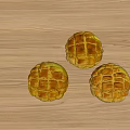 Three Fresh Golden Round Lattice Patterned Pastries on Wooden Tabletop