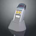 Gray Handheld Device With Digital Display Yellow Buttons And Charging Stand