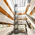 Modern Shopping Mall Interior Featuring Retail Stores Escalators Glass Skylights And Open Spaces