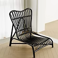 Black Modern Lounge Chair With Curved Woven Design In Indoor Wooden Floor Setting