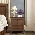 Brown Wooden Nightstand With Fringed Table Lamp Purple Flower Vase And Three Drawers