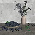 Fresh Blueberries in Bowl with Scattered Berries and Green Foliage in Vase on Gray Surface