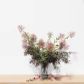 Pink Flowers in Green Vase with Scattered Petals on Wooden Table White Background