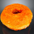Freshly Made Orange Glazed Donut With Shiny Surface And Central Hole