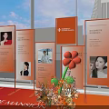 Orange Themed Exhibition Display With Photo Boards Text Content And Flower Decorations