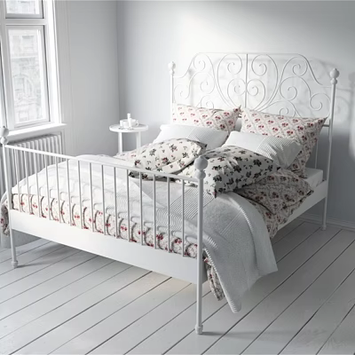 White Metal Bed With Decorative Headboard Floral Pillows Quilt And Bedside Table In White Bedroom 3d model