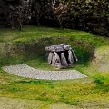 Natural Stone Structure in Circular Sunken Grassland with Trees and Pebble Ground