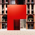 Red Storefront Facade Of Brick Building With Arched Windows And Glass Doors
