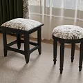Two Black Stools With Patterned Fabric Seats In Room With Curtains And Carpet