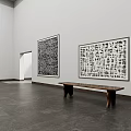 Spacious White Gallery Interior Featuring Large Black White Abstract Paintings Wooden Benches Dark Stone Floor