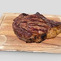 Perfectly Grilled Juicy Steak On Wooden Cutting Board With Charred Edges