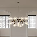 Transparent Glass Globe Chandelier with Light Bulbs Hanging Over White Walls and Arched Black Windows