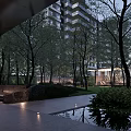 Modern Residential Landscape With High Rise Building Trees Lawn Glass Structure Pathway And Evening Lighting