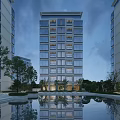 Modern High Rise Residential Building With Glass Curtain Walls Pool Trees Reflection And Evening Lighting