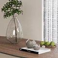 Transparent Teardrop Vase With Green Plant On Wooden Tabletop And Decorative Green Fruits Gray Spheres