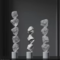 Three Modern Stacked Stone Like Floor Lamps Illuminated On Dark Background