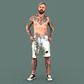 Tattooed Shirtless Man Wearing Shorts Standing With Hands On Hips In Gray Background