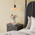 Stylish Black Bedside Table with Vase of Flowers Stacked Books and Drawer