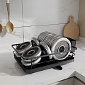 Black Dish Drying Rack With Stacked Plates And Wooden Utensils On Marble Kitchen Countertop