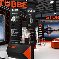STUBBE Exhibition Booth Design With Orange And Black Display Area Reception Desk And People