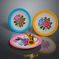 Colorful Household Items Including Blue Yellow Plates And Golden Teapot On Pink Tray