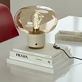 Modern Transparent Globe Table Lamp with Gold Base on PRADA GUCCI Books and Candle Tray