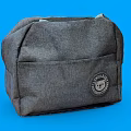 Gray Canvas Bag with Front Pocket and Round Badge on Blue Background