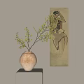 Earth Toned Ceramic Vase with Leafy Green Branches on Small Table Beside Vertical Wall Painting