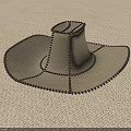 Beige Cowboy Hat With Black Stitching Detail On Light Fabric Surface