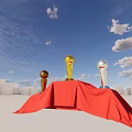 Decorative Ornament Set With Gold Silver Trophies On Red Draped Platform Against Blue Sky