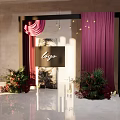 Elegant Floral Installation With Black Frame Purple Curtains And Logo Sign