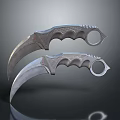 Two Metal Karambit Knives With Curved Blades And Finger Hole Handles