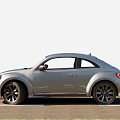 Silver Volkswagen Beetle Car With Classic Design And Black Wheels Parked On Road
