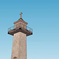European Architecture Tower With Cross Top Balcony And Stone Base Against Blue Sky