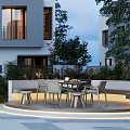 Modern Evening Garden With Circular Seating Area Paved Flooring Table Chairs Green Plants And Lighting