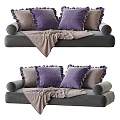 Gray Sectional Sofa With Ruffled Purple And Brown Pillows And Soft Blanket