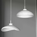 Two White Pendant Lights With Rippled Shades Lit Against Dark Background