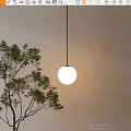 Round White Pendant Light Hanging With Soft Glow Near Green Tree Branches Against Beige Wall