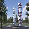 Tall Outdoor Sculpture With Circular Holes And Colorful Patterns In Park With Trees
