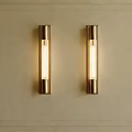 Gold Cylindrical Wall Lamps Mounted on Beige Wall With Decorative Frame Lighting