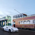 White Sports Car And Black Vehicle Parked Near Vintage Tram At Station