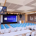 Modern Conference Room With Blue Chairs White Tables Large Screen Windows 10 And Wooden Decor