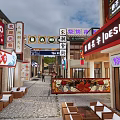 Vibrant Commercial Street With Traditional Chinese Signs Shops And Outdoor Seating